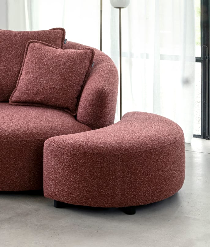 Rode XOOON Cervos fauteuil met kussen en bijpassende halfronde hocker voor een glazen raam met licht gordijn